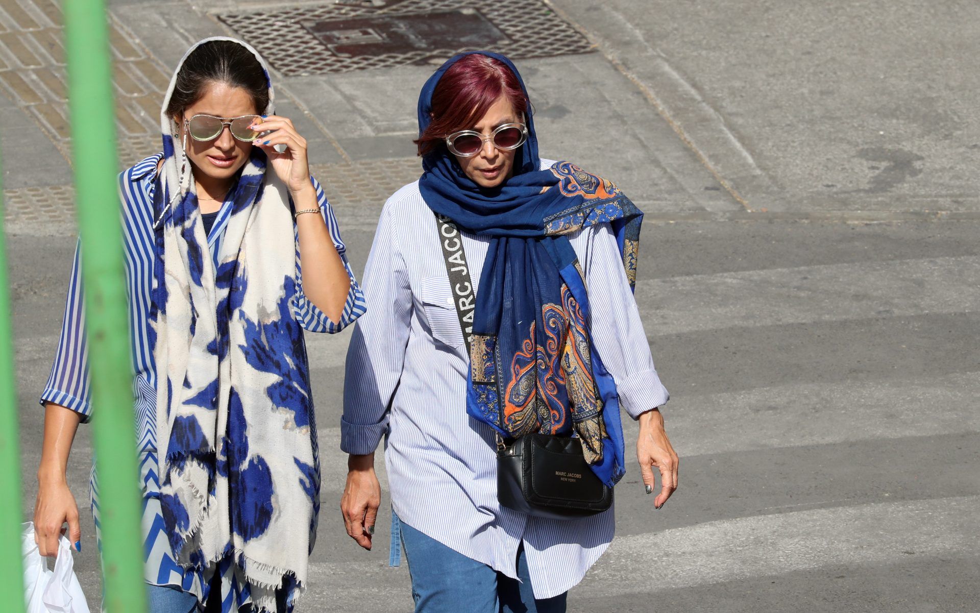     Dos mujeres caminan con la cabeza semi cubierta con un pañuelo por una calle de Tehran.  Irán vive una oleda de protestas por la muerte de Mahsa Amini.