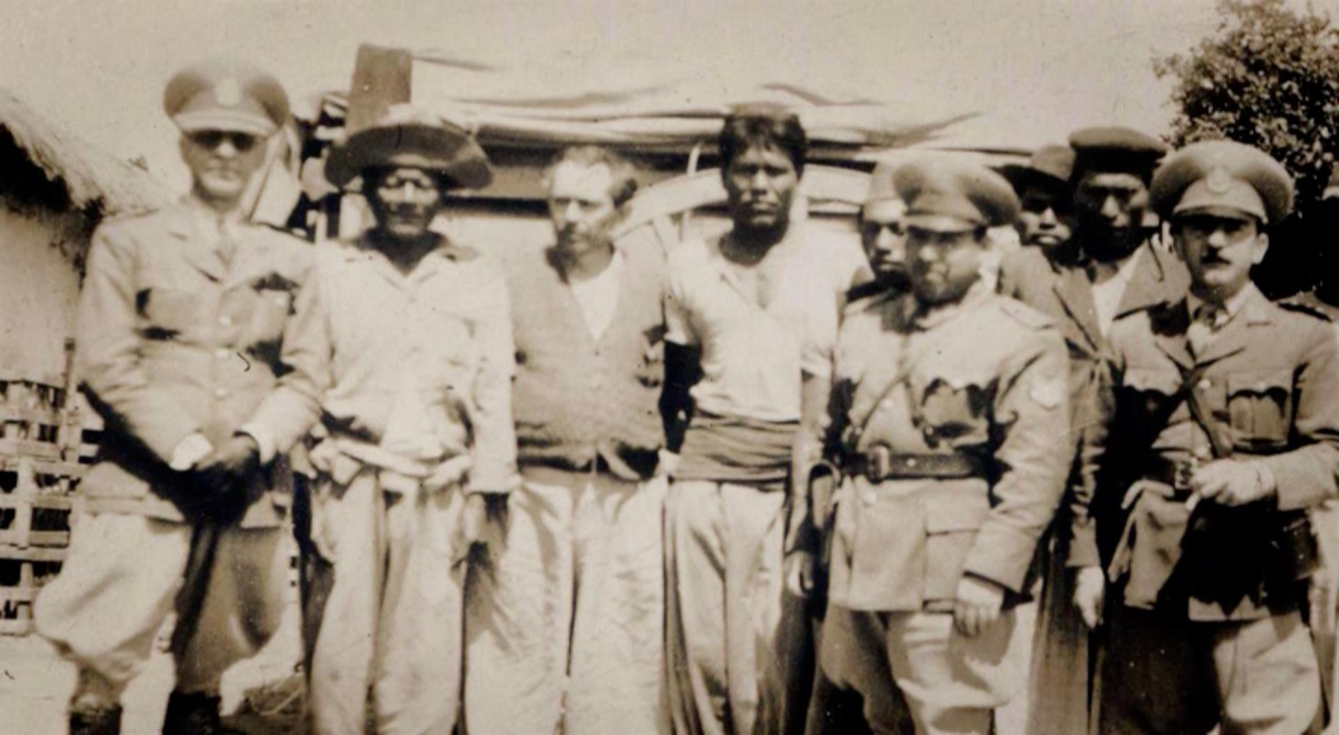 Fotografía cedida por Valeria Mapelman, Directora del Documental "Octubre Pilagá, relatos sobre el silencio" de un fotograma del documental que muestra varios pilagás capturados por Emilio Fernández Castellanos, comandante de la Gendarmería Nacional (hombre con bigote situado a la derecha de la imagen).  EFE/Valeria Mapelman