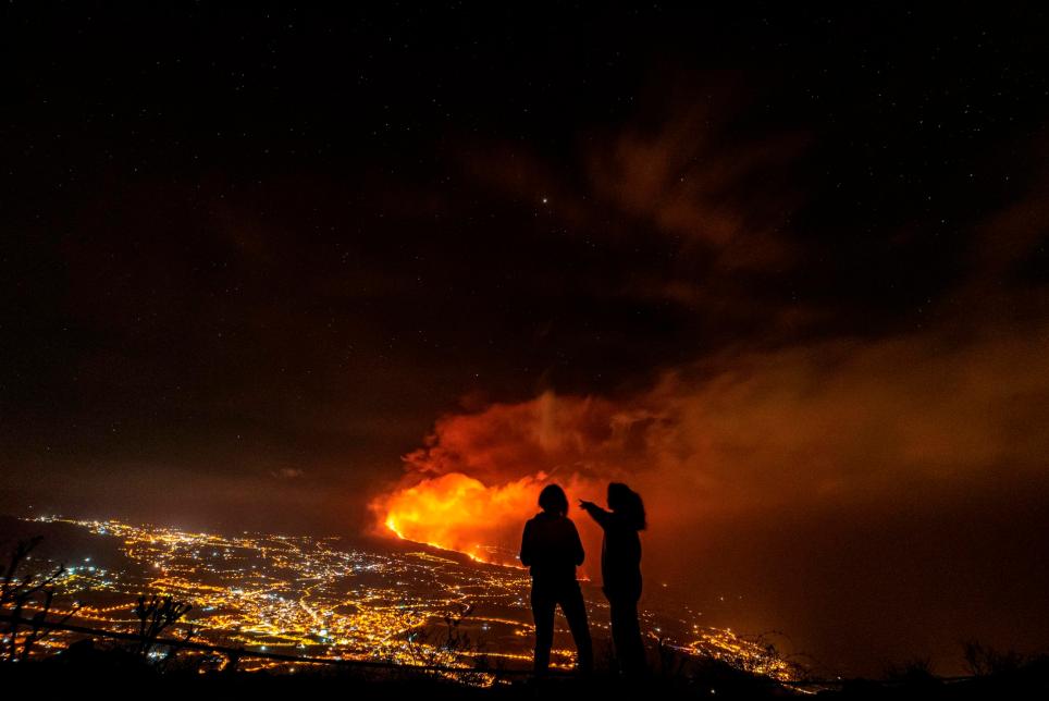 Dos jóvenes contemplan desde el valle de Aridane, en La Palma, la erupción en Cumbre Vieja al anochecer de este martes. EFE/Miguel Calero
