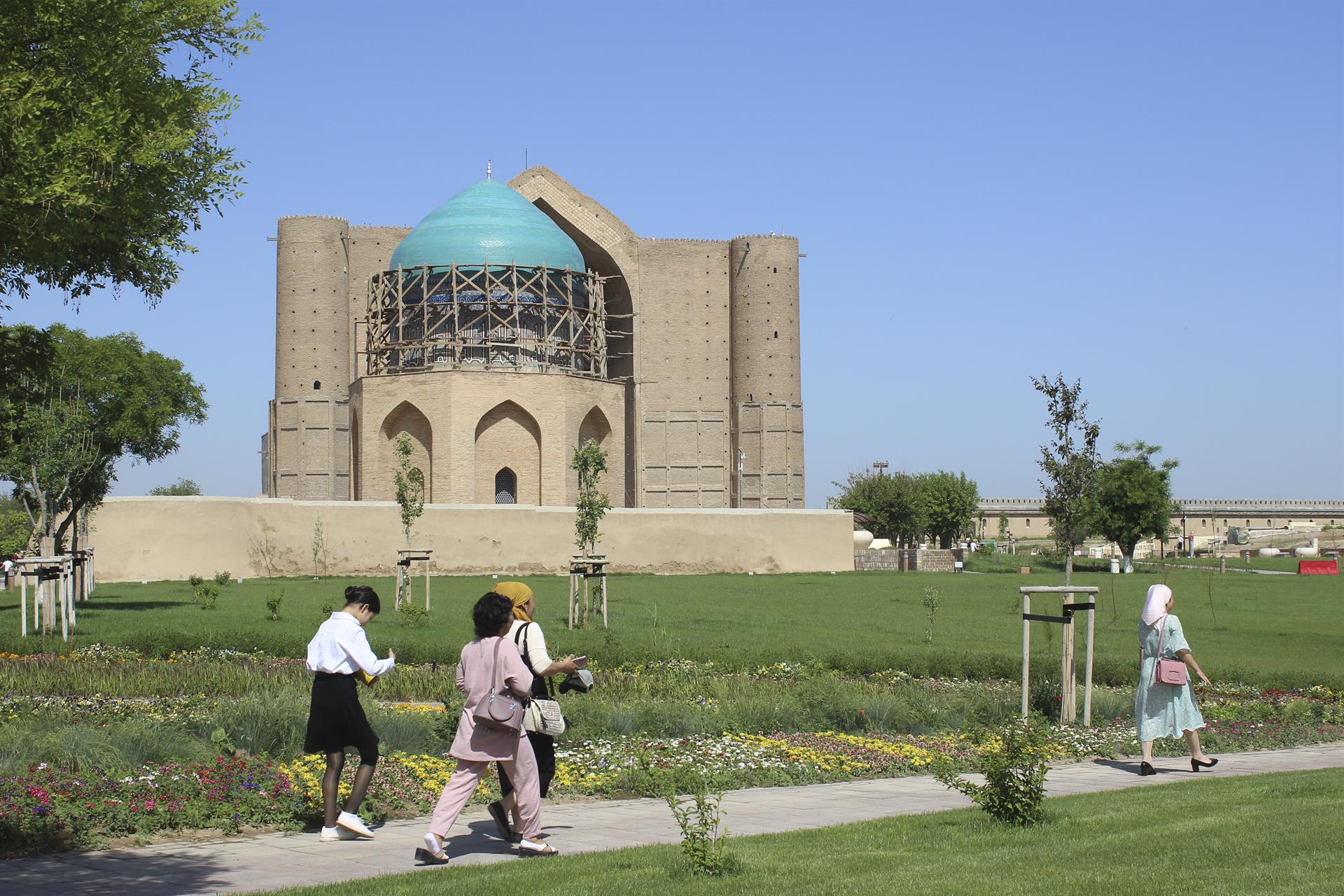 Women walk in front of the Khoja Ahmed Yasawi mausoleum next to the International Tourism University campus in Turkestan, Kazakhstan, Monday. EFE/ Luis Angel Reglero