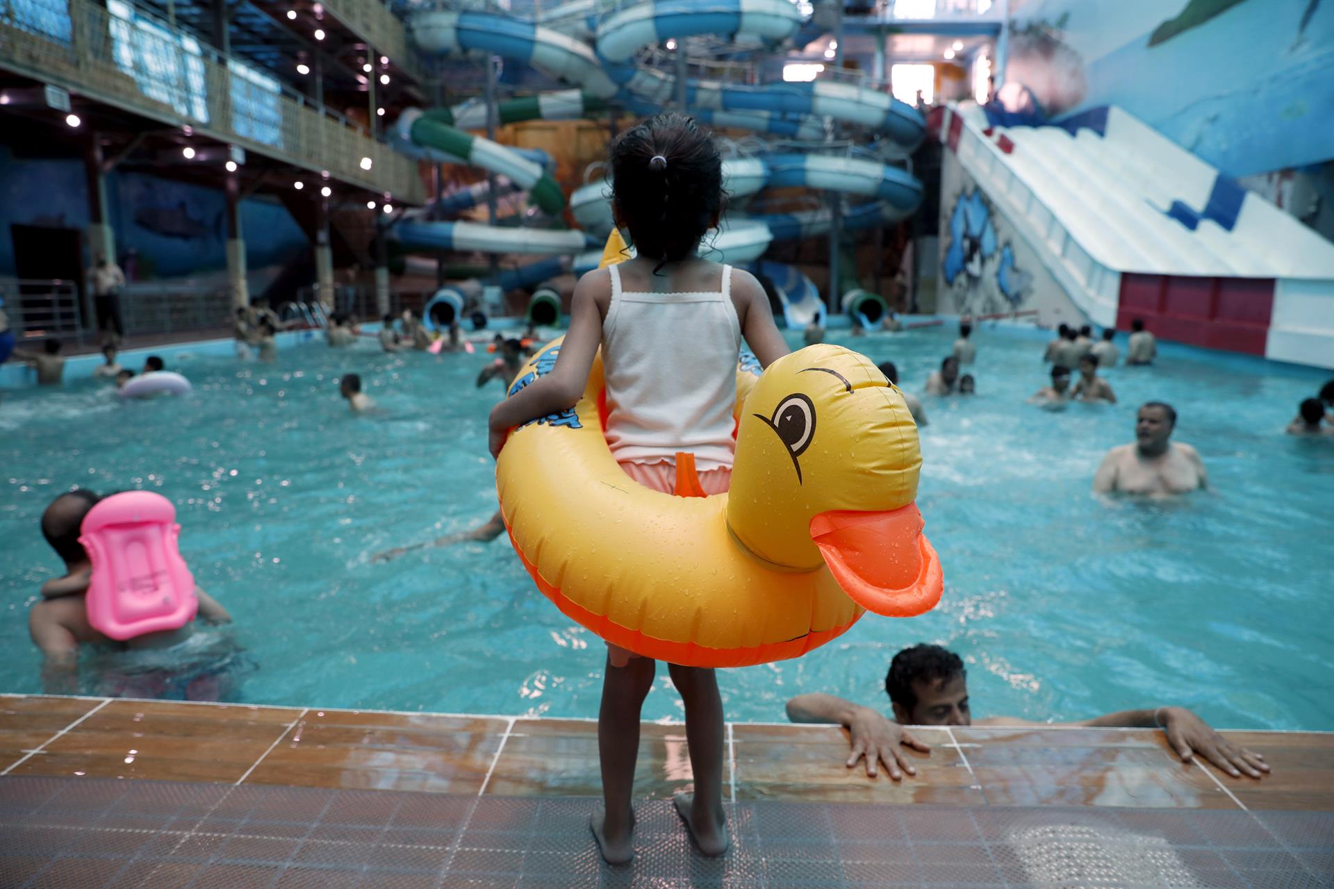 Imagen de archivo de una niña con un flotador delante de una piscina. EFE/EPA/YAHYA ARHAB