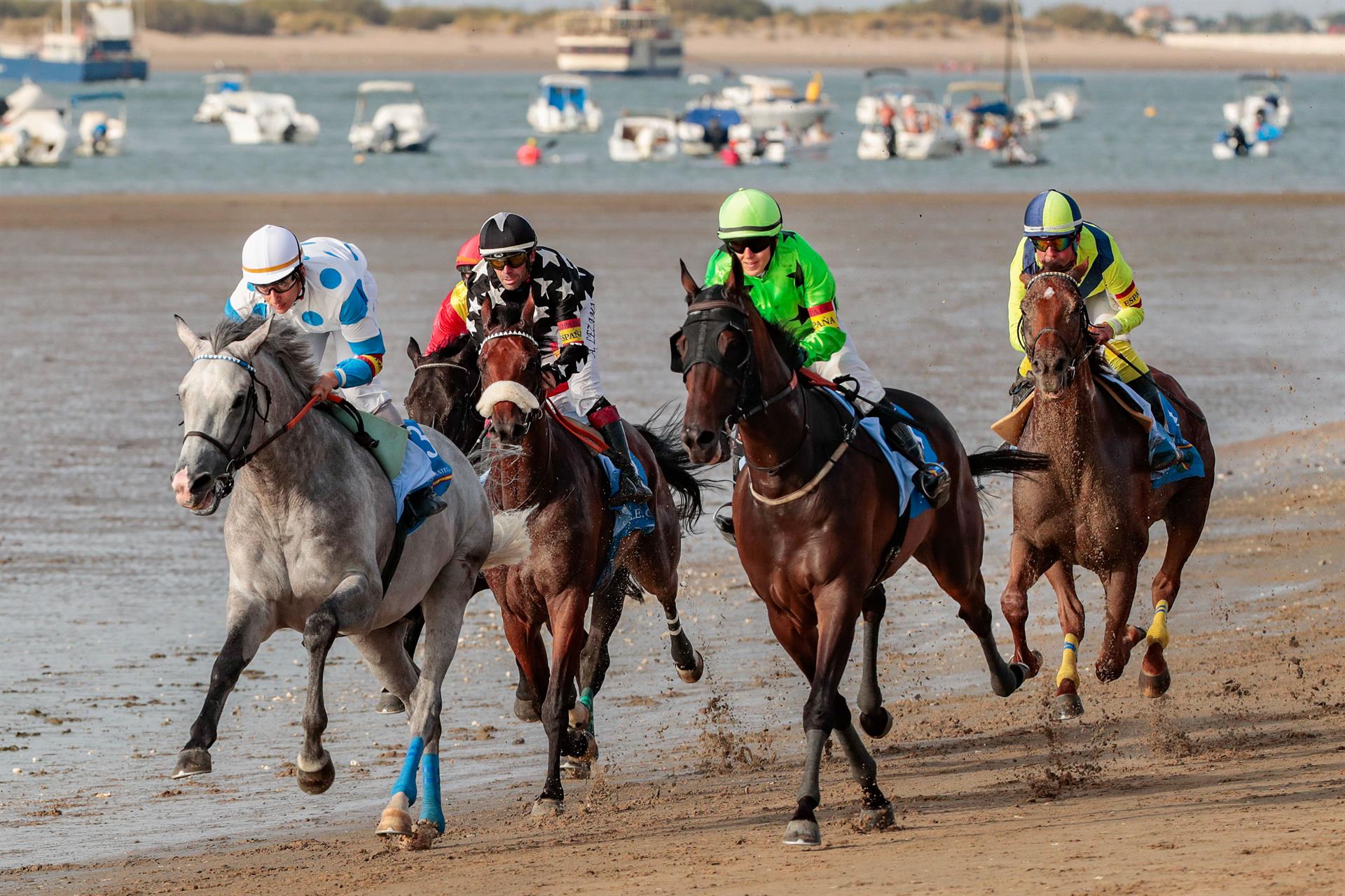 Una de las pruebas del primer día del primer ciclo de la 177ª edición de las carreras de caballos celebradas en las playas situadas frente al Parque Nacional Doñana, en Sanlúcar de Barrameda (Cádiz). EFE/Román Ríos.