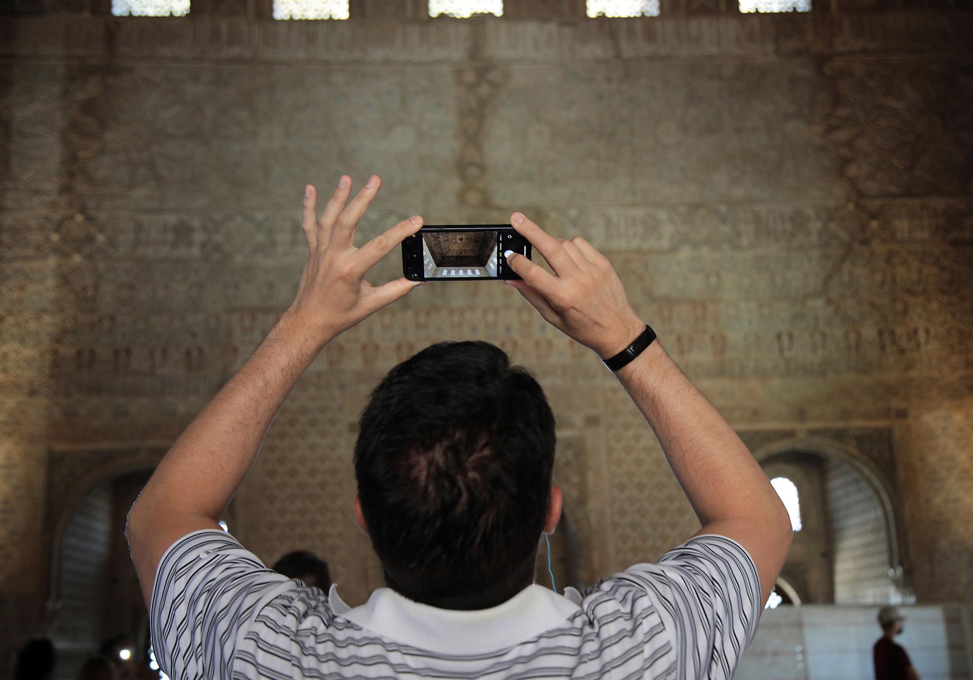 Un turista toma una fotografía en el interior de la Alhambra. EFE/Archivo