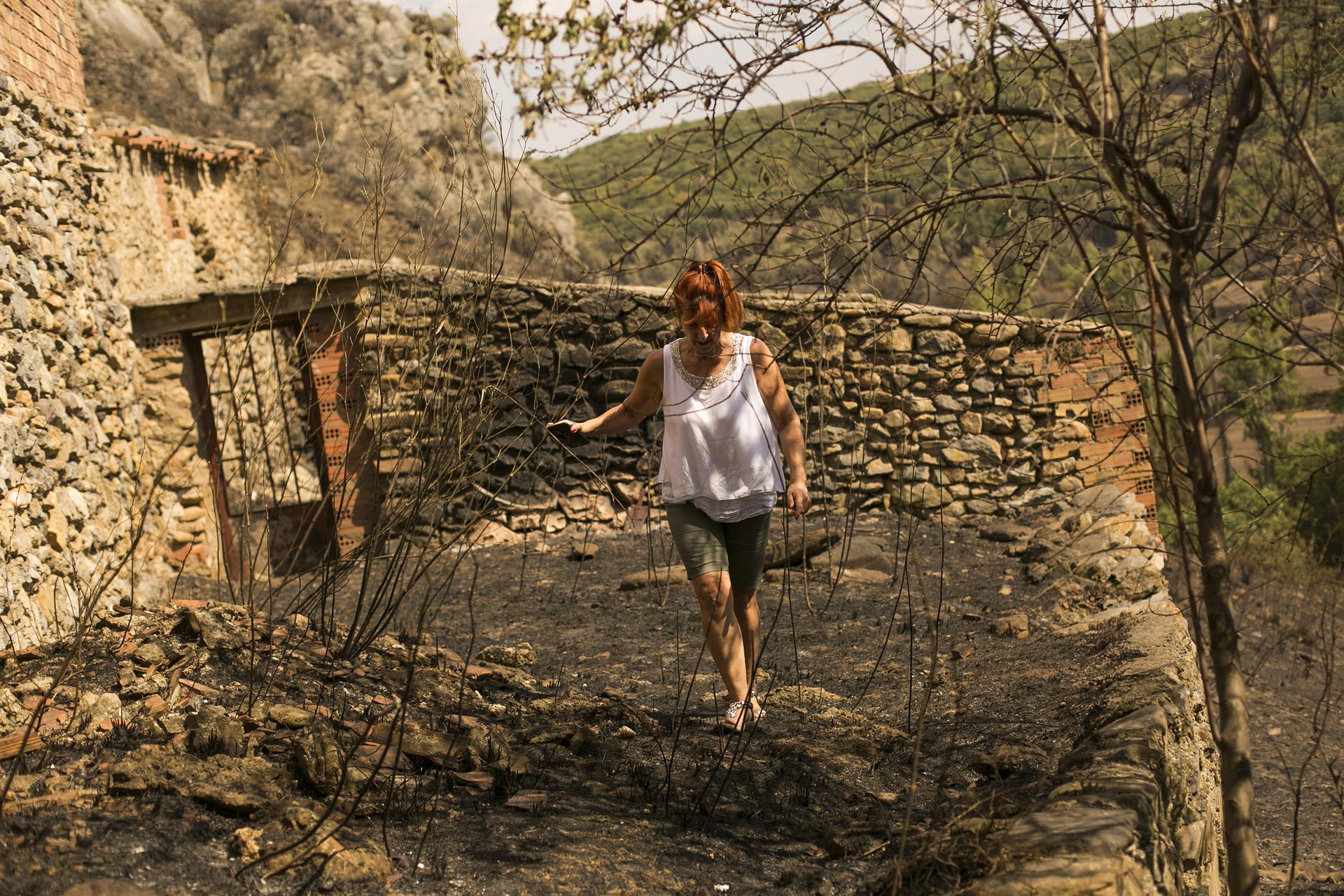 Feli, una vecina del pueblo de Añón del Moncayo (Zaragoza), regresa a su casa después del incendio que ha calcinado unas 6.000 hectáreas. EFE/ Toni Galán