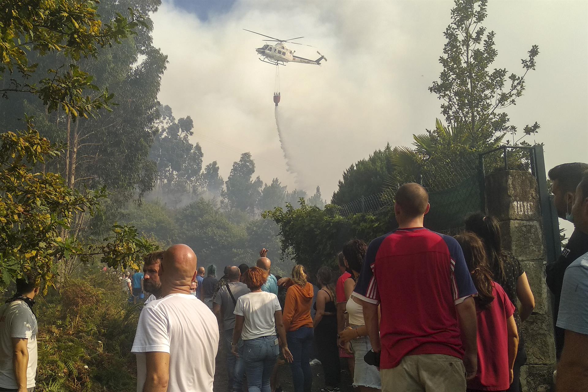 Los vecinos de Moaña (Pontevedra) repelen el fuego a las puertas de sus casas. EFE/Ramón Martínez
