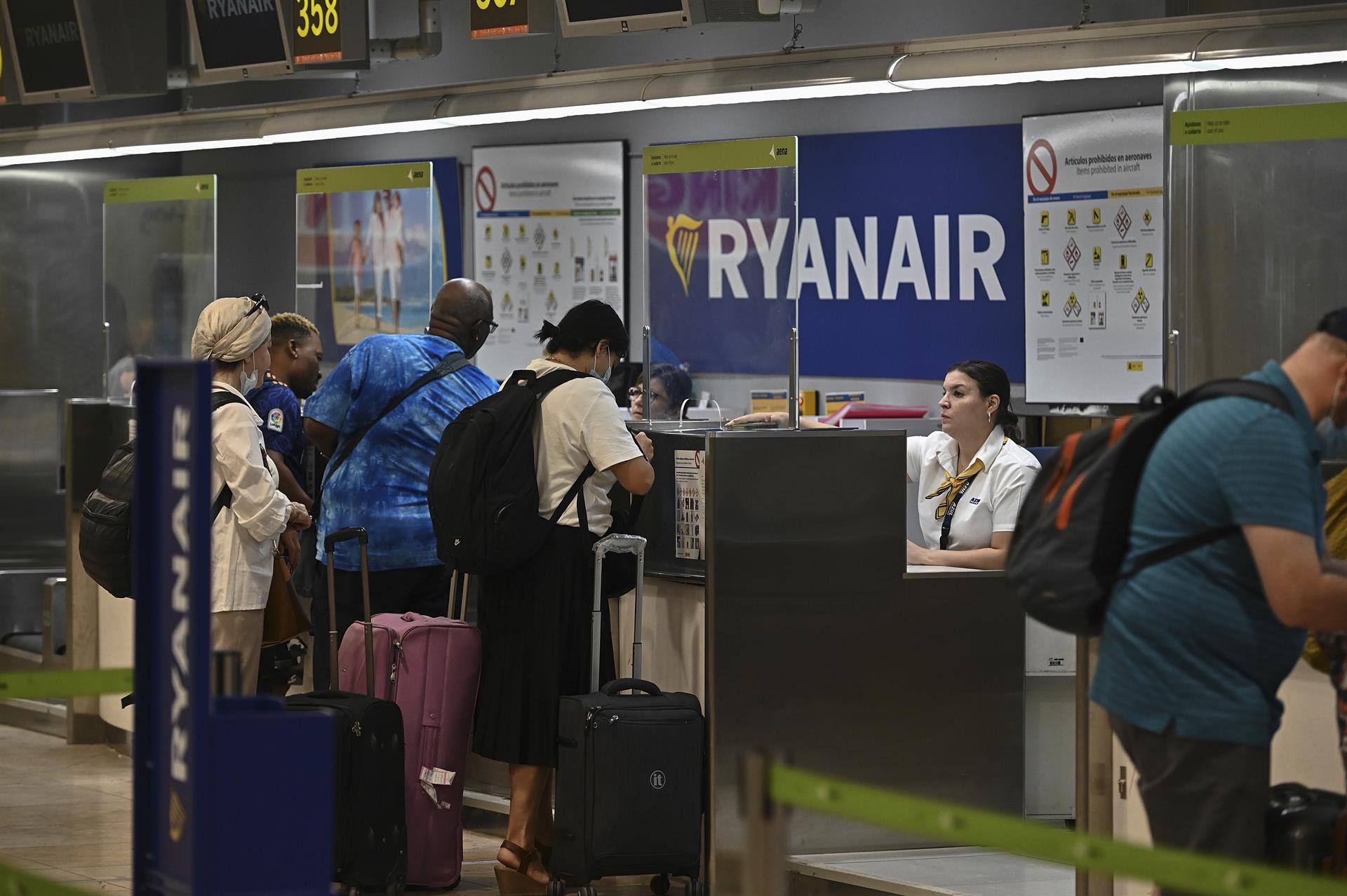 Varios pasajeros facturan sus maletas en los mostradores de Ryanair. EFE/Archivo