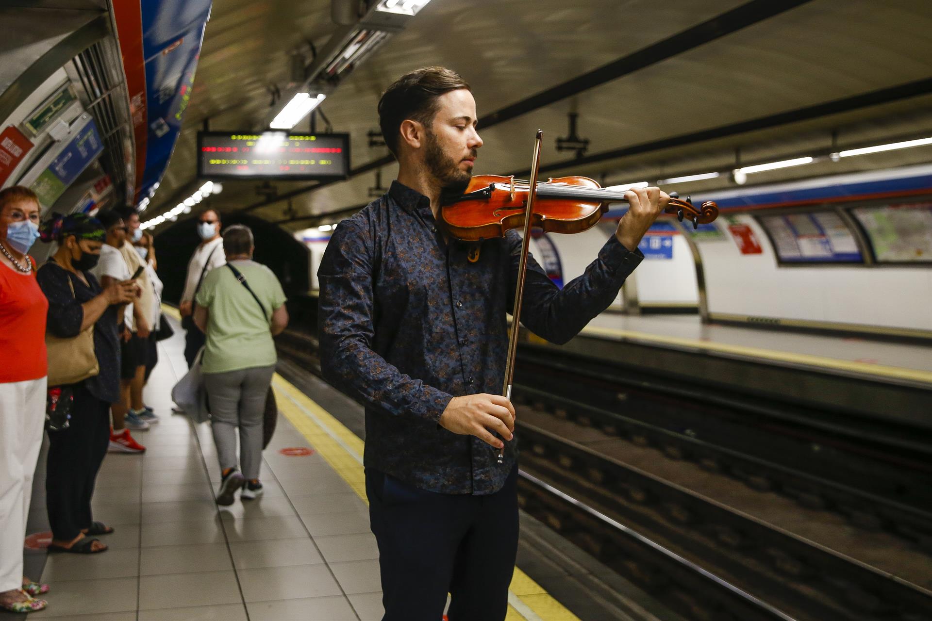Un violinista en el andén de la estación de Ópera, este miércoles en el que se ha presentado un proyecto piloto para reproducir piezas de música clásica por la megafonía de las estaciones de la red de Metro. EFE/ Victor Casado