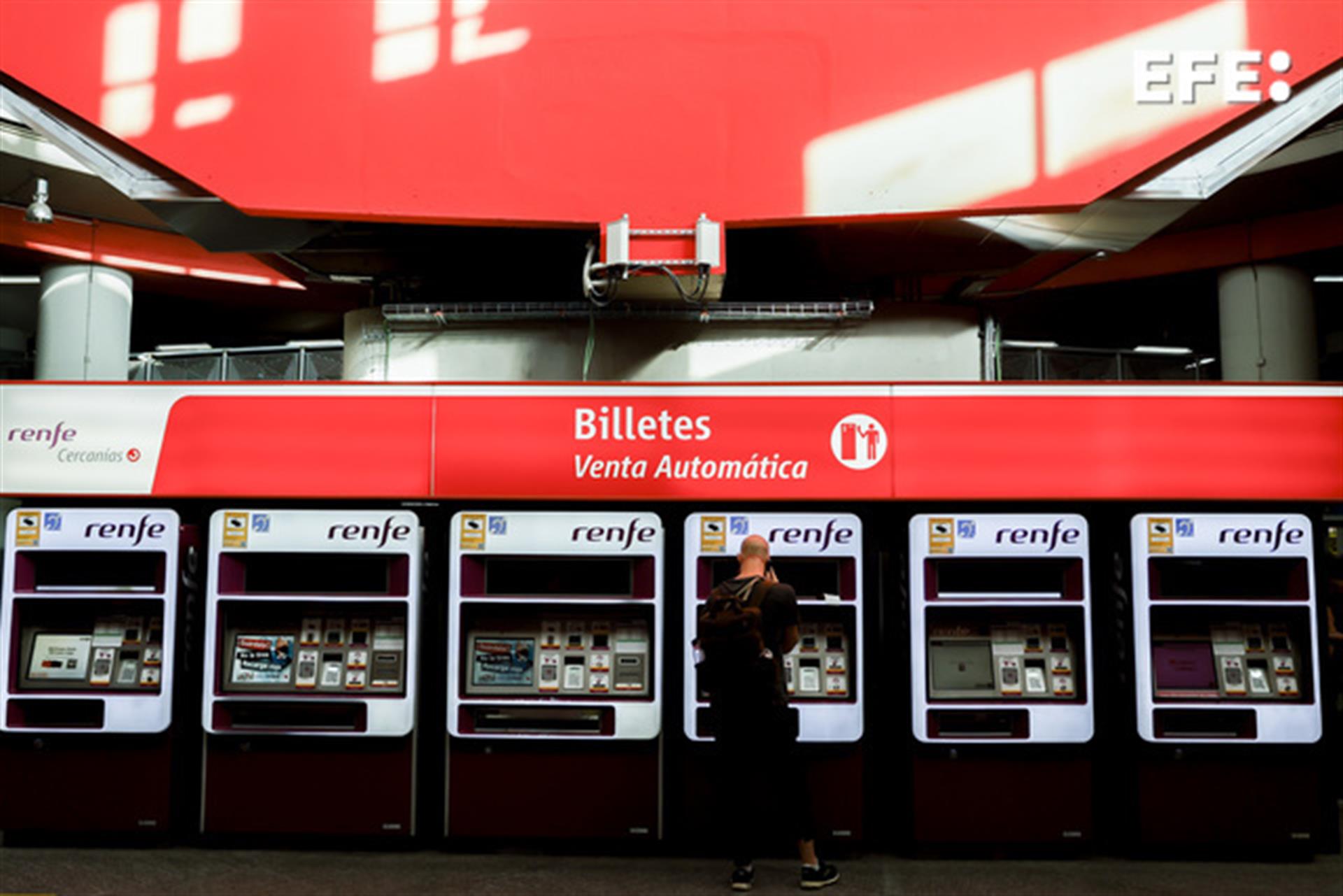 Viajeros gestionan la compra de sus abonos en máquinas expendedoras de billetes en una estación de Cercanías. EFE/Archivo
