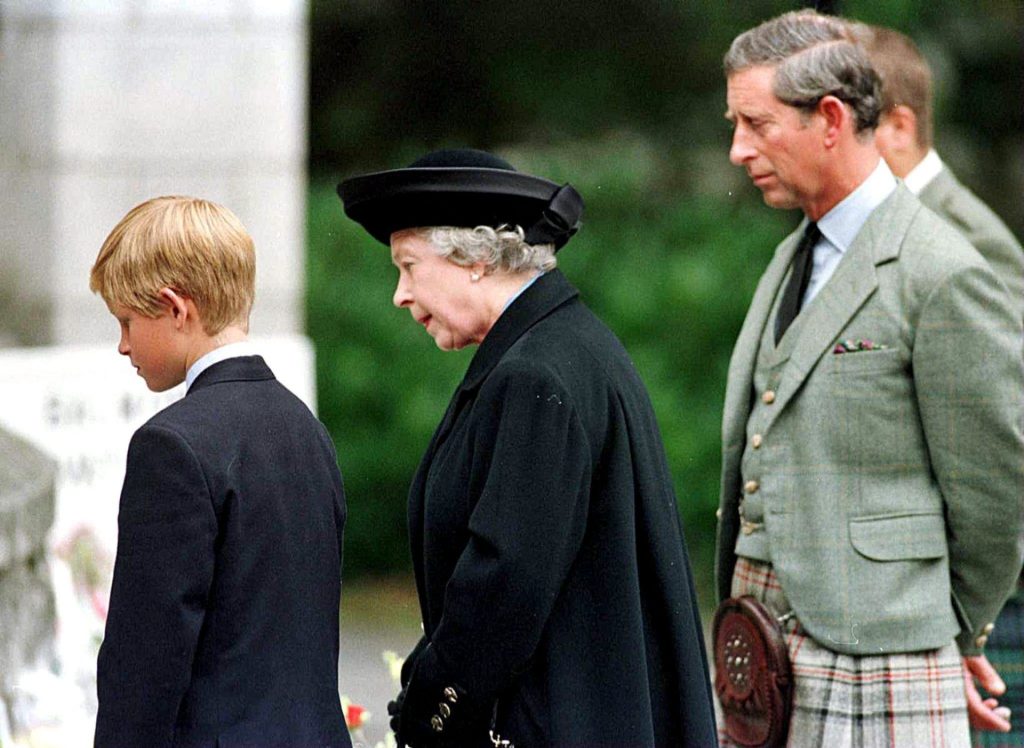 La reina Isabel II, su nieto, el príncipe Harry y su hijo, el príncipe Carlos, leen los mensajes escritos para la difunta Diana, princesa de Gales, dejados por los britaánicos como homenaje tras su muerte, en 1997