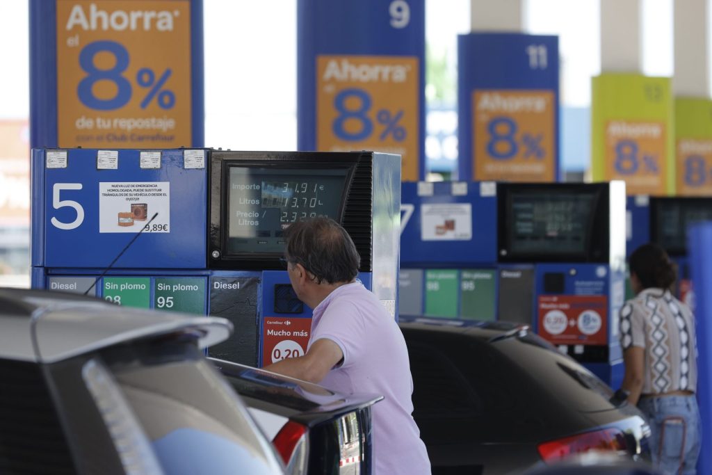 Dos personas repostan en una gasolinera de Madrid