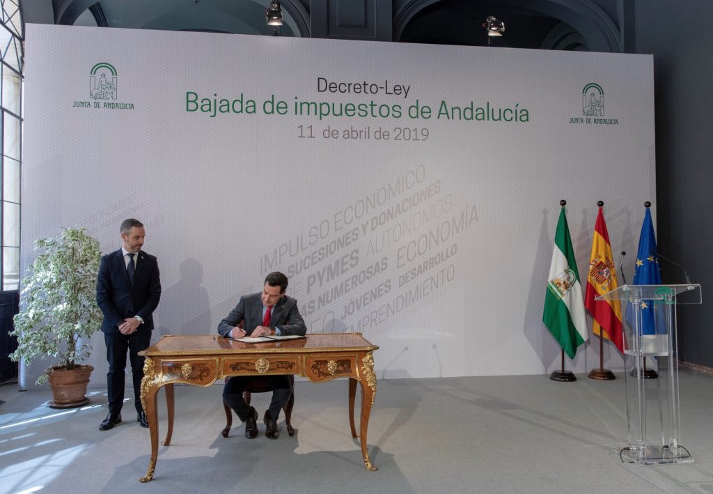 El presidente andaluz, Juanma Moreno, en la firma del decreto que rebaja varios de los impuestos