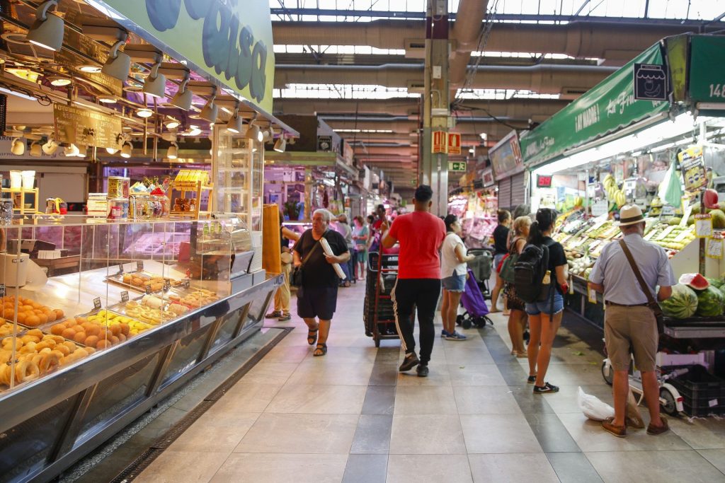 Varias personas hacen la compra en un mercado madrileño