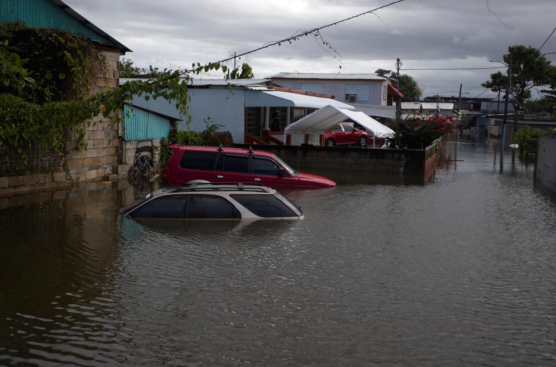 Fotografía de archivo de dos vehículos en medio de una calle inundada debido a las fuertes lluvias en Cataño (Puerto Rico). EFE/ Thais LLorca