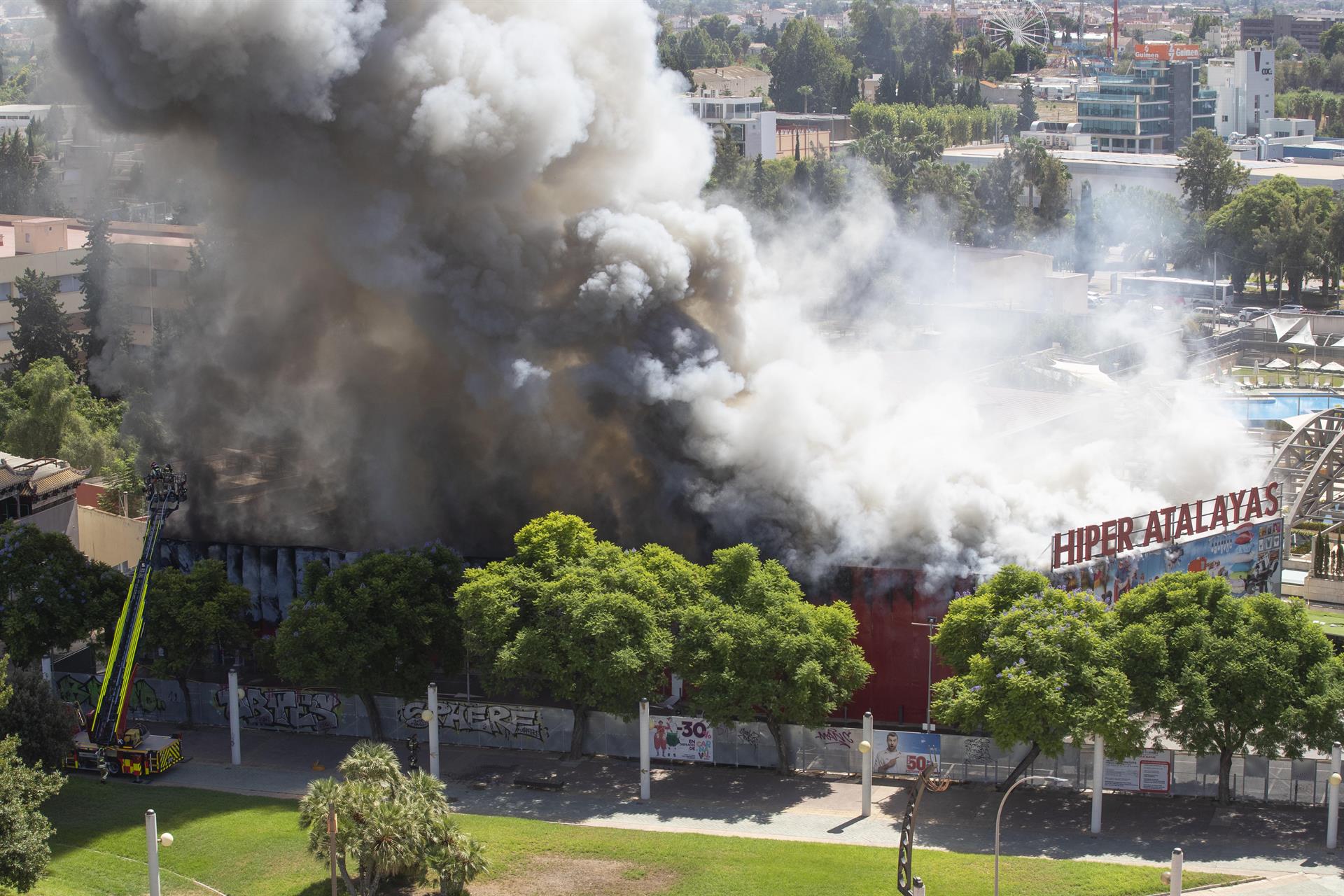 Más de una veintena de bomberos con cinco vehículos trabajan desde primera hora de la tarde de este martes en la extinción de un incendio originado en un bazar chino, en la zona comercial de Atalayas, en Murcia.EFE/Marcial Guillén