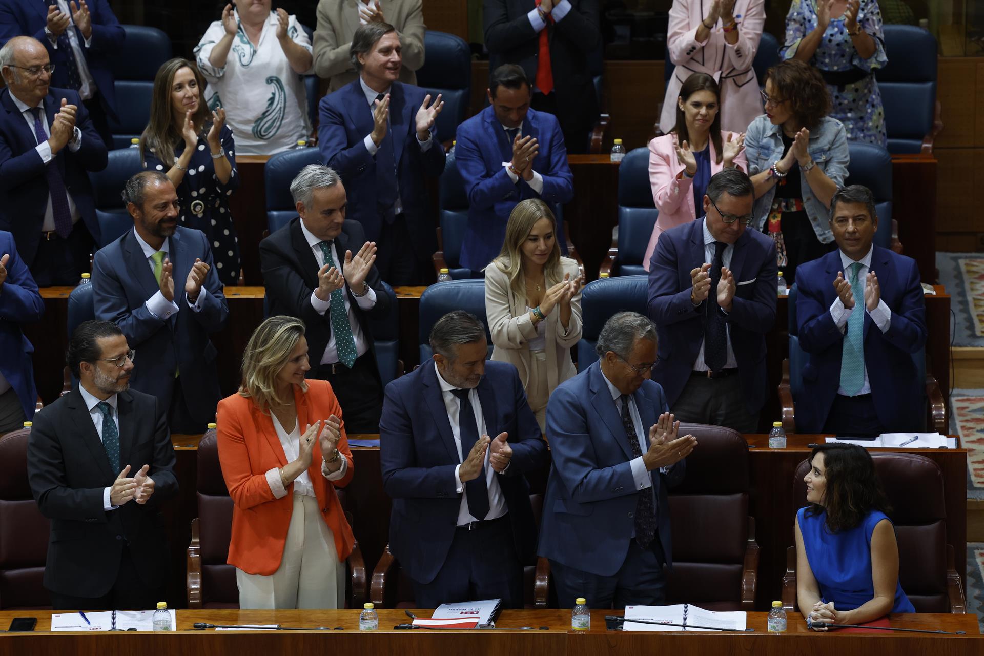 La presidenta de la Comunidad de Madrid, Isabel Díaz Ayuso (d), recibe los aplausos de sus consejeros y de los diputados populares durante la primera sesión del debate del estado de la región en la Asamblea de Madrid, este lunes. EFE/ J.J. Guillén