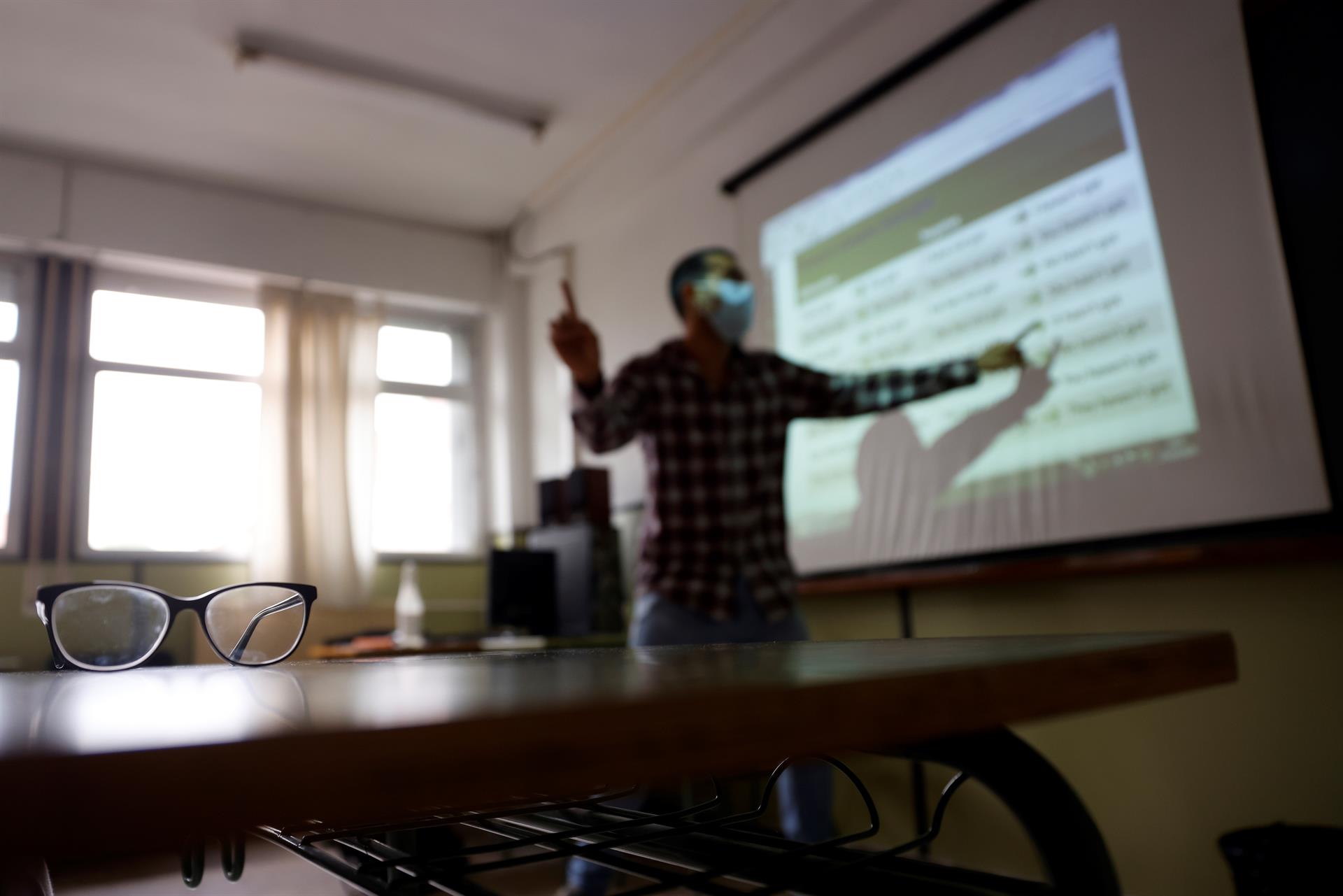 Un profesor da clase con la mascarilla en un aula de instituto. EFE/Mariscal/Archivo