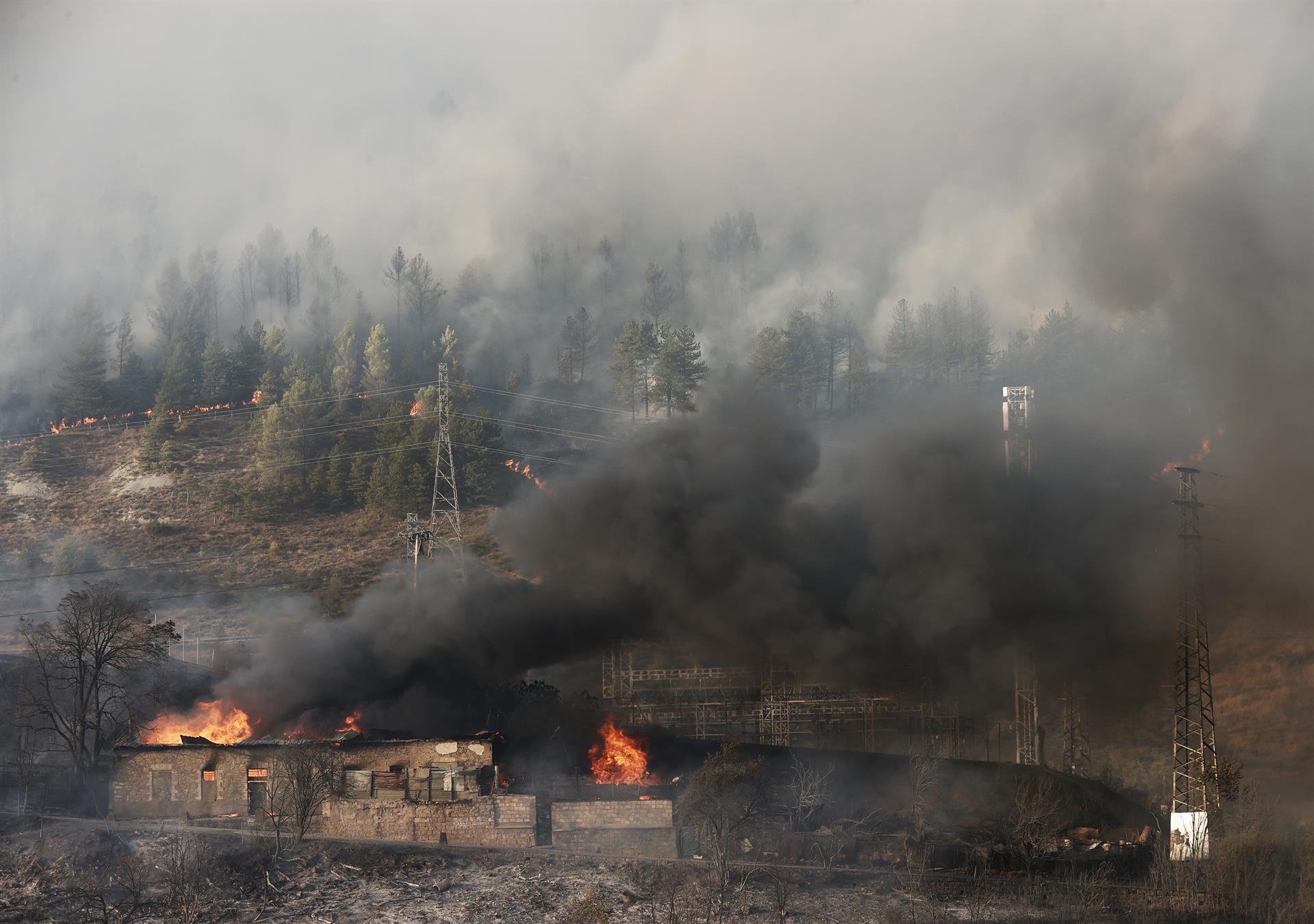 Efectivos de emergencias, con medios aéreos, trabajan en la extinción de un incendio declarado esta tarde en el monte Ezkaba. EFE/ Jesus Diges.