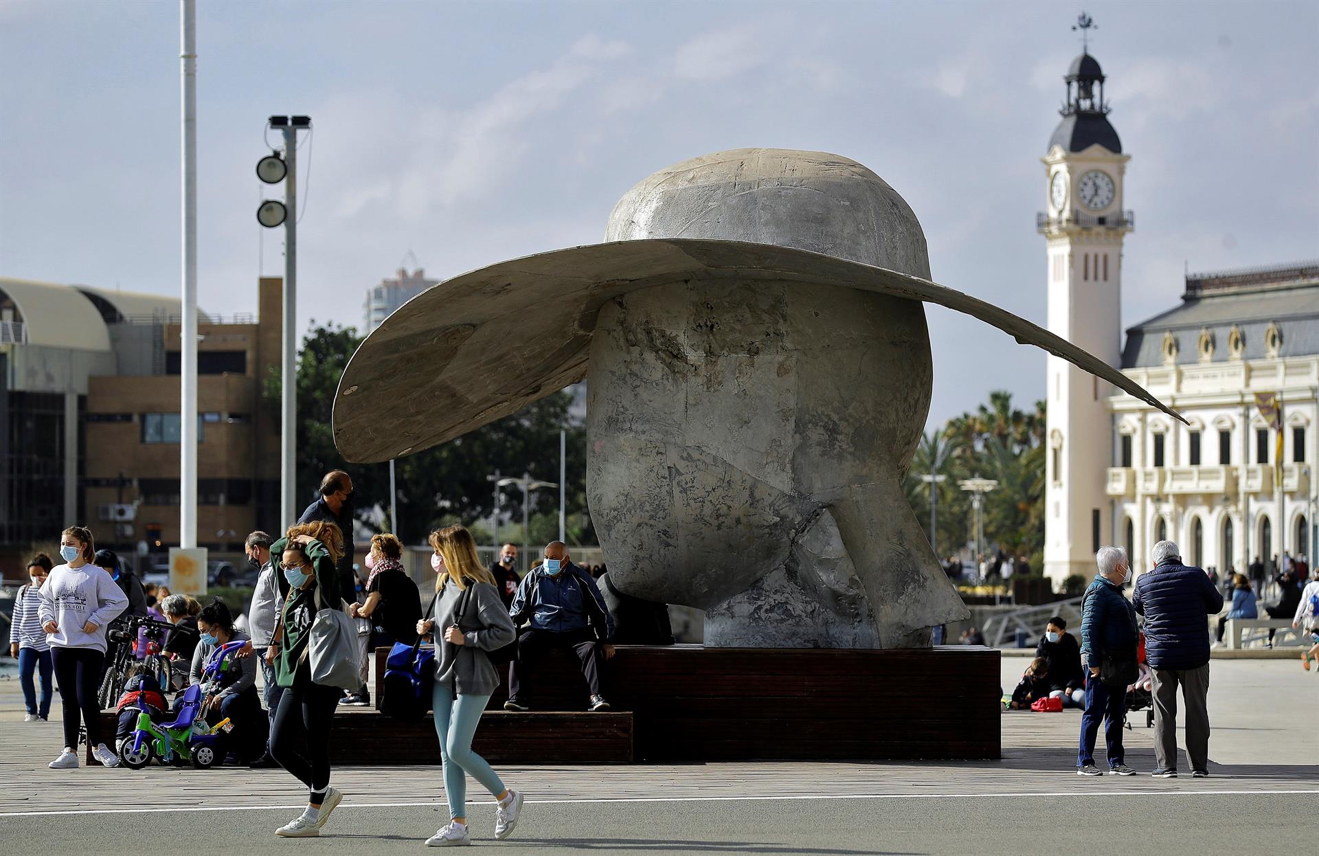 Un grupo de personas descansan, este domingo, junto a "La Pamela" la escultura del artista Manolo Valdés situada en La Marina del Puerto de Valencia. EFE/Manuel Bruque
