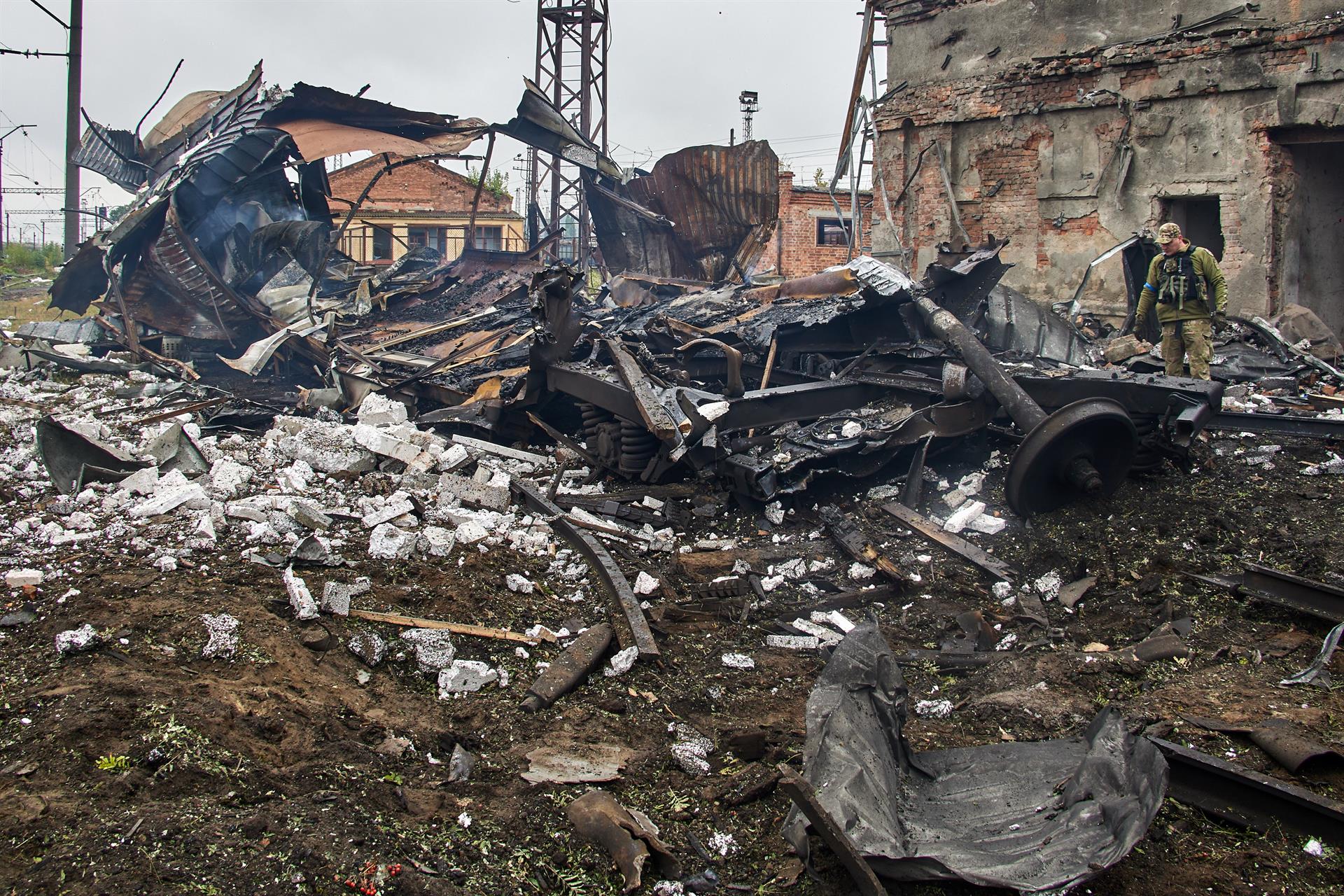 Un militar ucraniano observa un vagón de carga destruido atascado en los bombardeos rusos, en Járcov (Ucrania) este 21 de septiembre. EFE/EPA/SERGEY KOZLOV