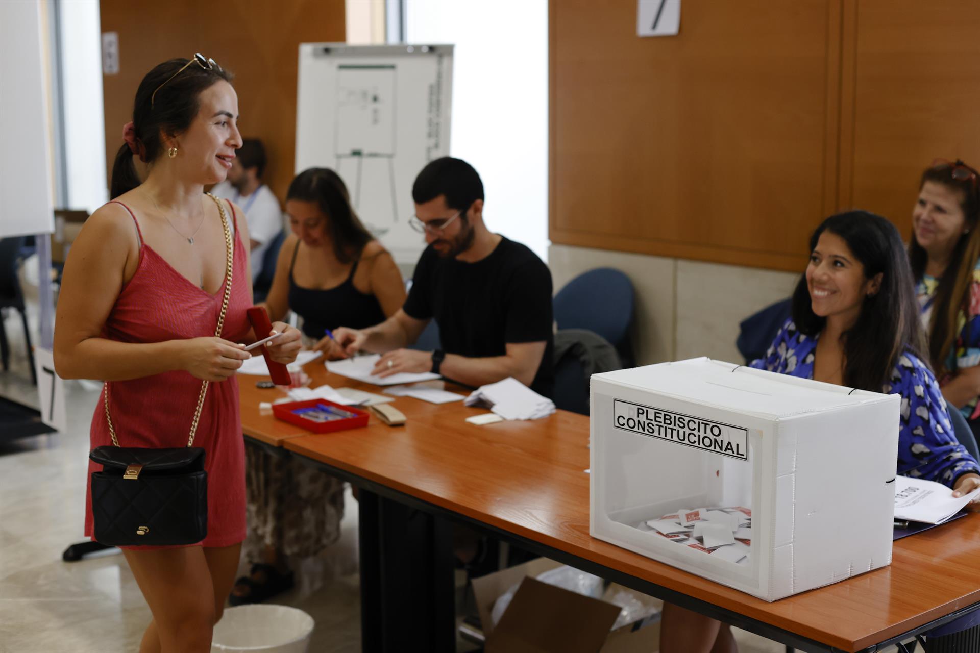 Varias personas acuden a un centro de votación instalado este domingo en Barcelona para que los chilenos afincados en España voten si aprueban o rechazan la nueva Constitución. EFE/Toni Albir