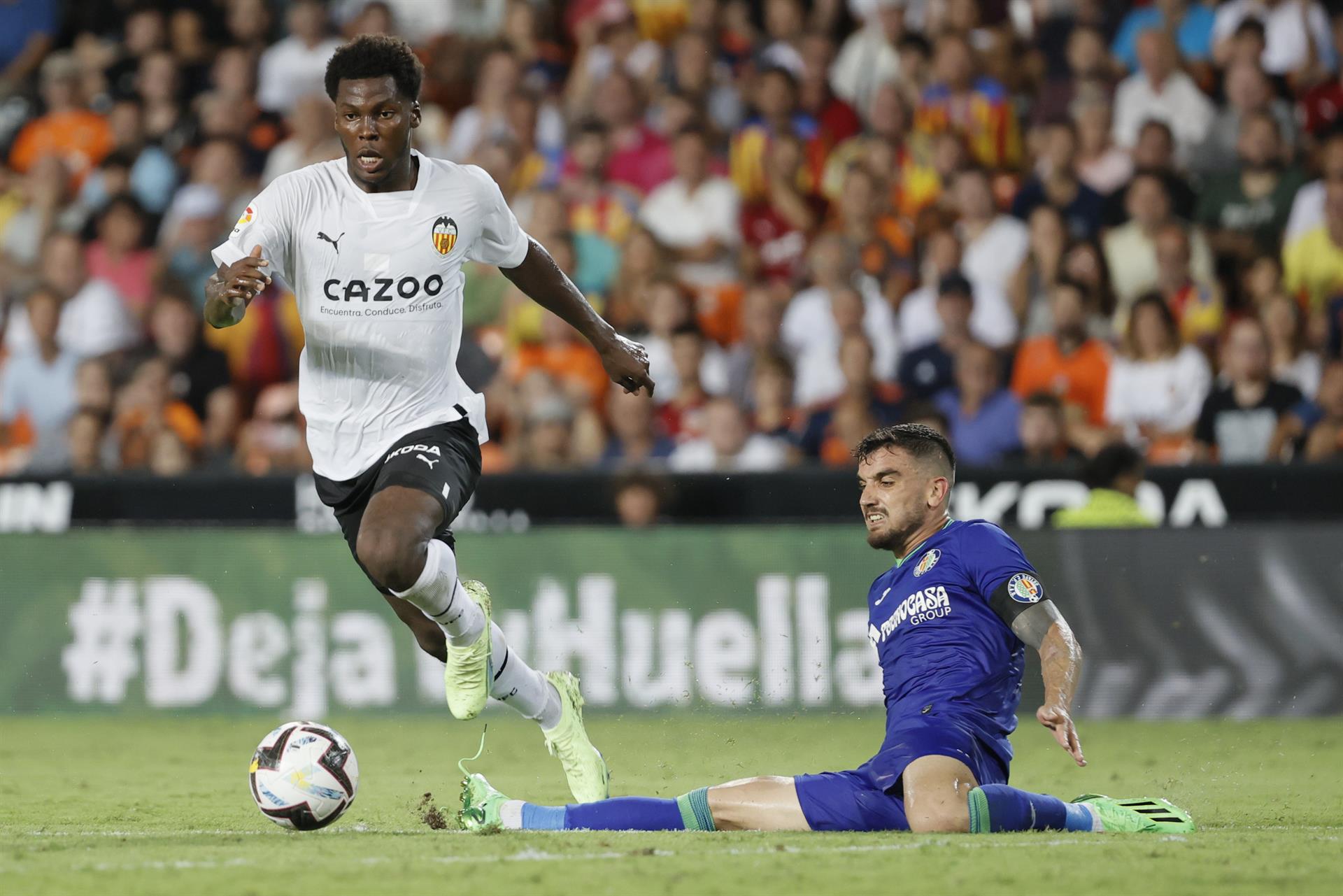 El centrocampista del Valencia CF Yunus Musah (iz) se escapa de un rival en un partido. EFE/Juan Carlos Cárdenas