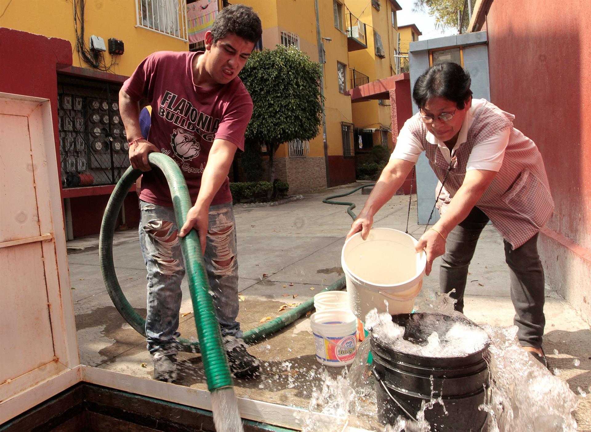Fotografía de archivo que muestra a una mujer llenando sus cubetas con agua, en Ciudad de México (México). EFE/Mario Guzmán