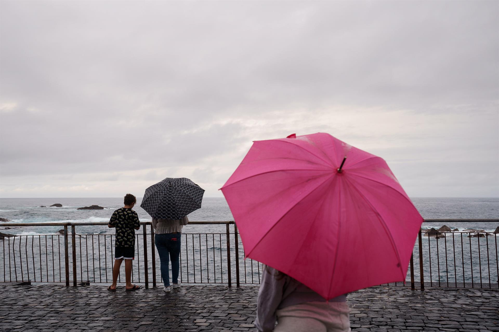 Foto tomada el domingo por la tarde: unas personas contemplan el mar este domingo en la costa del municipio de Garachico, en el norte de Tenerife.EFE/Ramón de la Rocha