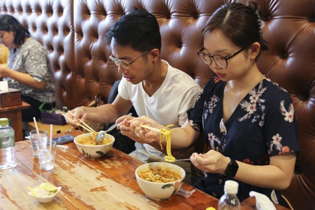 Una pareja toma sopa tailandesa