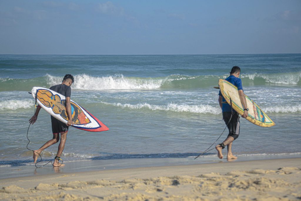 Dos jóvenes surfean las aguas de Gaza
