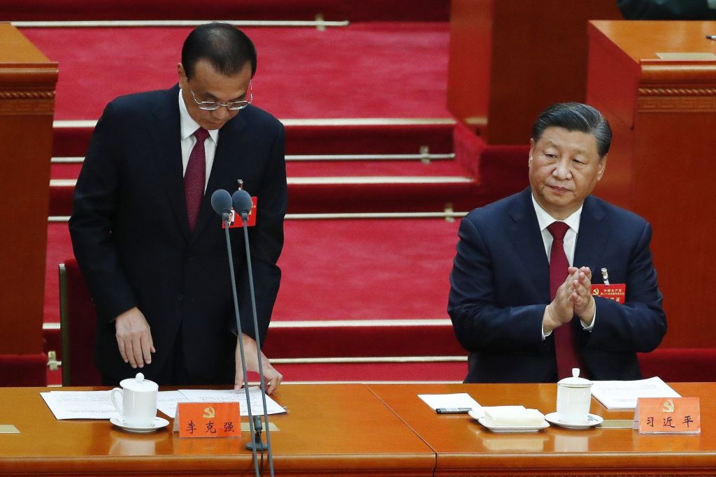 El presidente chino, Xi Jinping, (derecha) aplaude al primer ministro, Li Keqiang, (izquierda) tras su intervención en la sesión inaugural del XX Congreso del PartIdo Comunista chino, en el Gran Salón del Pueblo de Pekín.