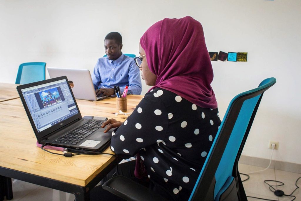 Binta Dème, única mujer del equipo y única diseñadora de videojuegos en Senegal, y Thierno Ndiaye, el desarrollador de ""Clean my beach"", trabajan con sus portátiles en Dakar (Senegal). Las empresarias de Oriente Medio y el Norte de África atrapadas entre muros y techos de cristal.