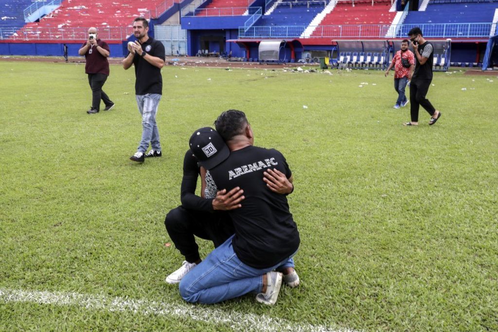 Varias personas se abrazan en el campo de Kanjuruhan, en Indonesia, tras la tragedia de ayer.  