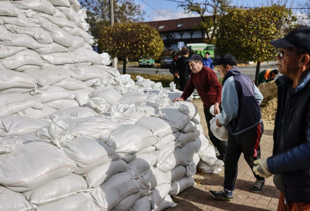 Un grupo de personas coloca sacos de arena en Mykolaiv, cuando Ucrania afirma que están sufriendo ataques a infraestructuras eléctricas