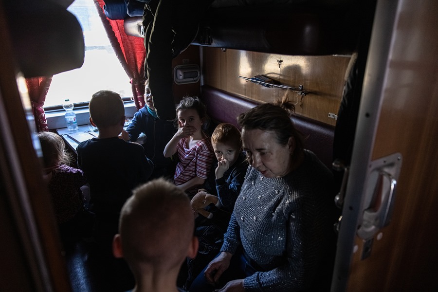 Órfãos ucranianos junto a uma professora em uma estação de trem em Zaporizhzhia, em março deste ano. EFE/Arquivo/Roman Pilipey