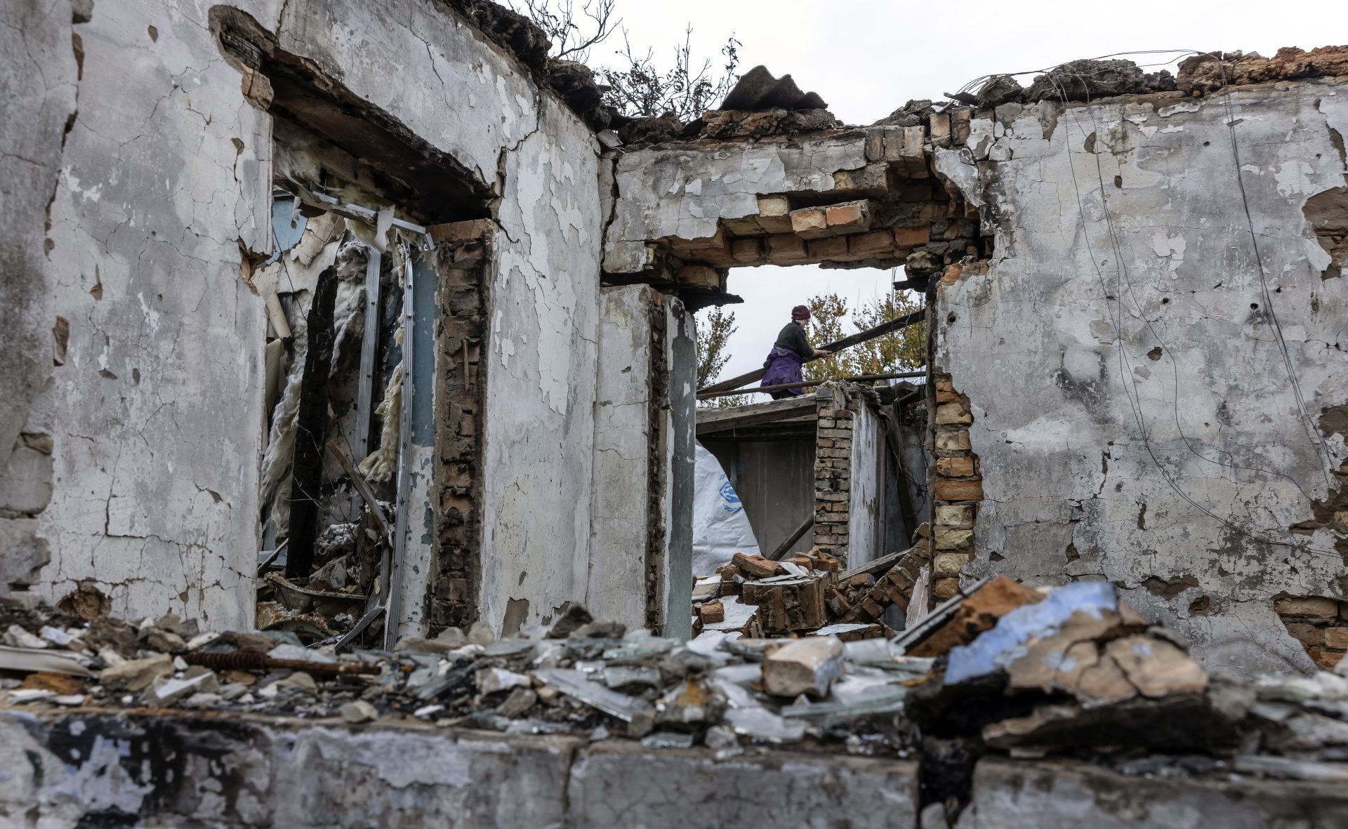 Un mujer ucraniana trabaja en el techo de su casa, en la aldea recuperada de Osokorivka, destruida en un bombardeo ruso.