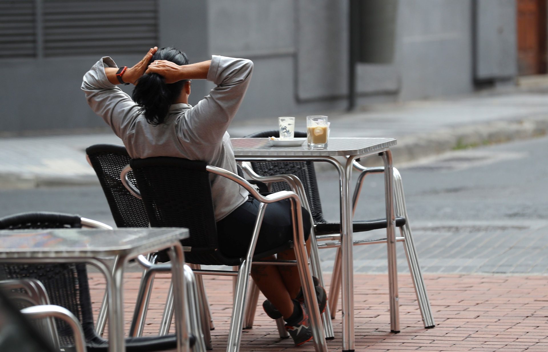 Una mujer toma café en una terraza