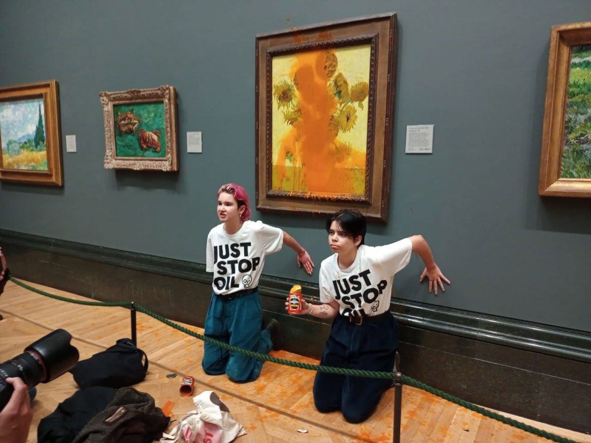 Dos manifestantes se arrodillan frente a la pintura a la pintura de Vincent Van Gogh de 1888 'Girasoles' en la Galería Nacional de Londres, tras lanzarle sopa de tomate Heinz.