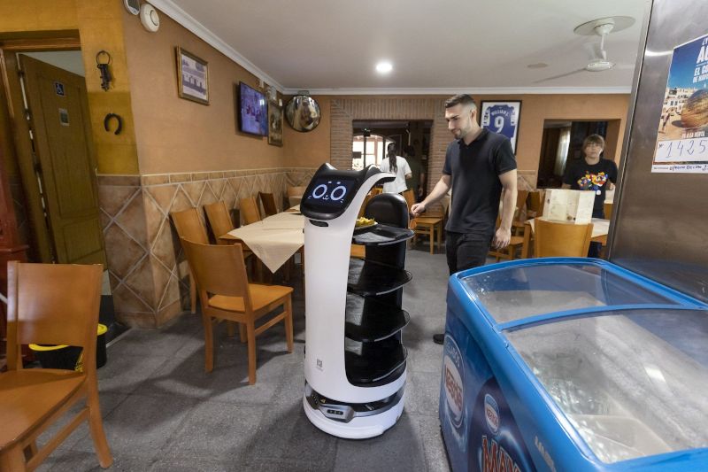 Un camarero con un robot camarero