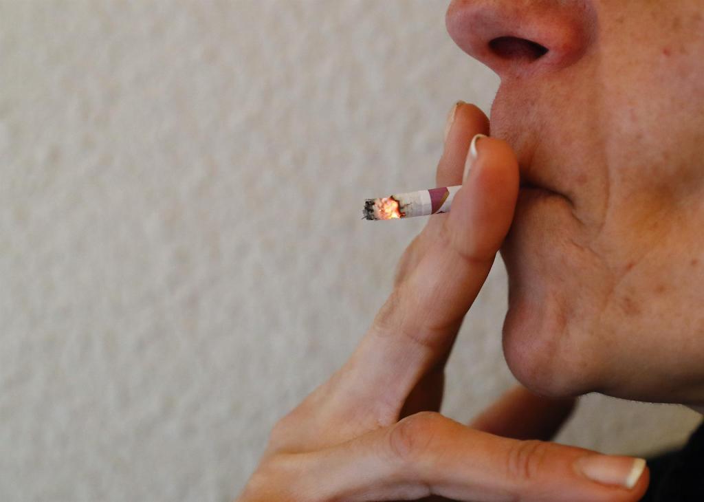 A person smokes a cigarette.