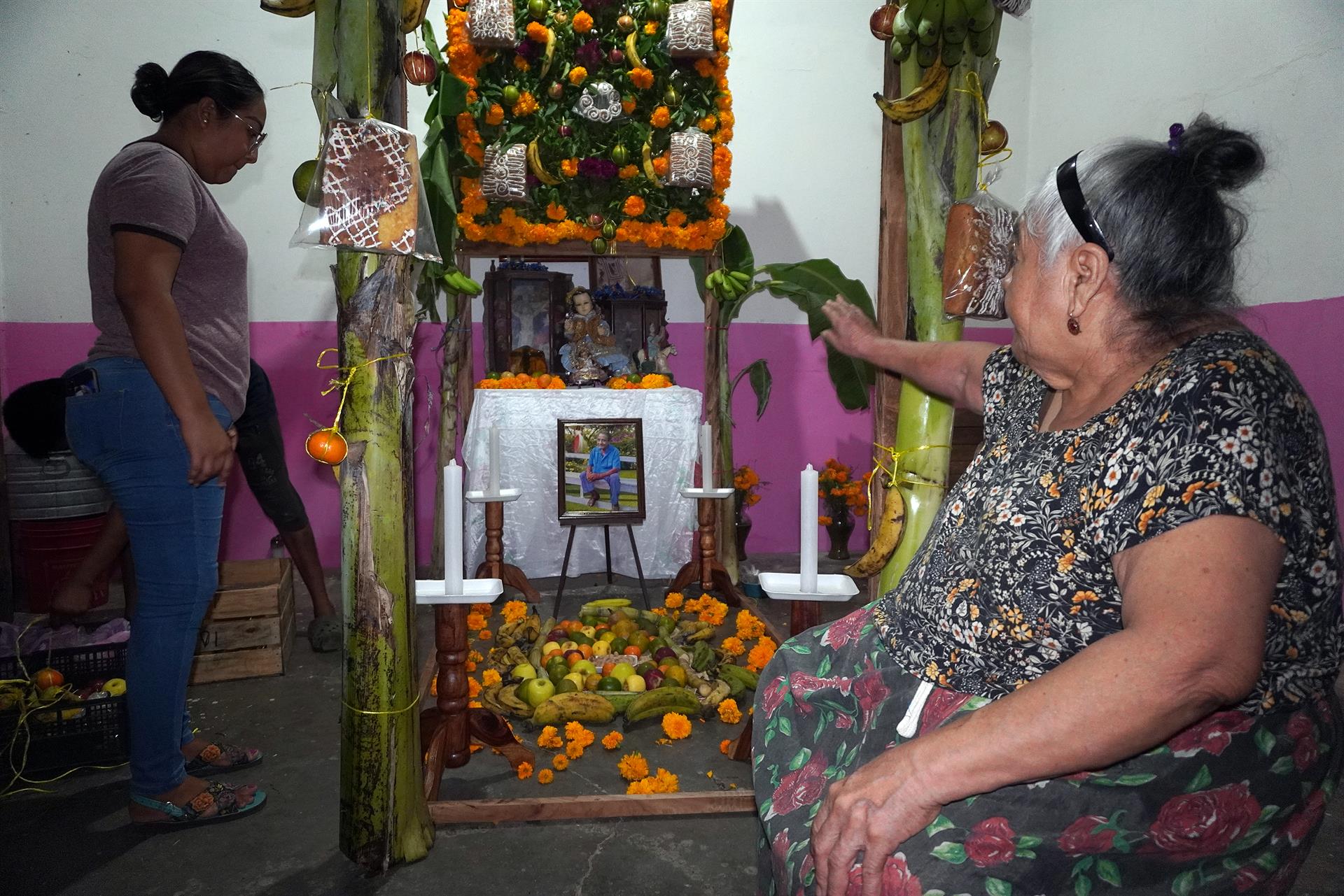Personas arreglan hoy una ofrenda dedicada a sus familiares fallecidos, en el municipio de Juchitán, estado de Oaxaca (México). EFE/Jesús Méndez