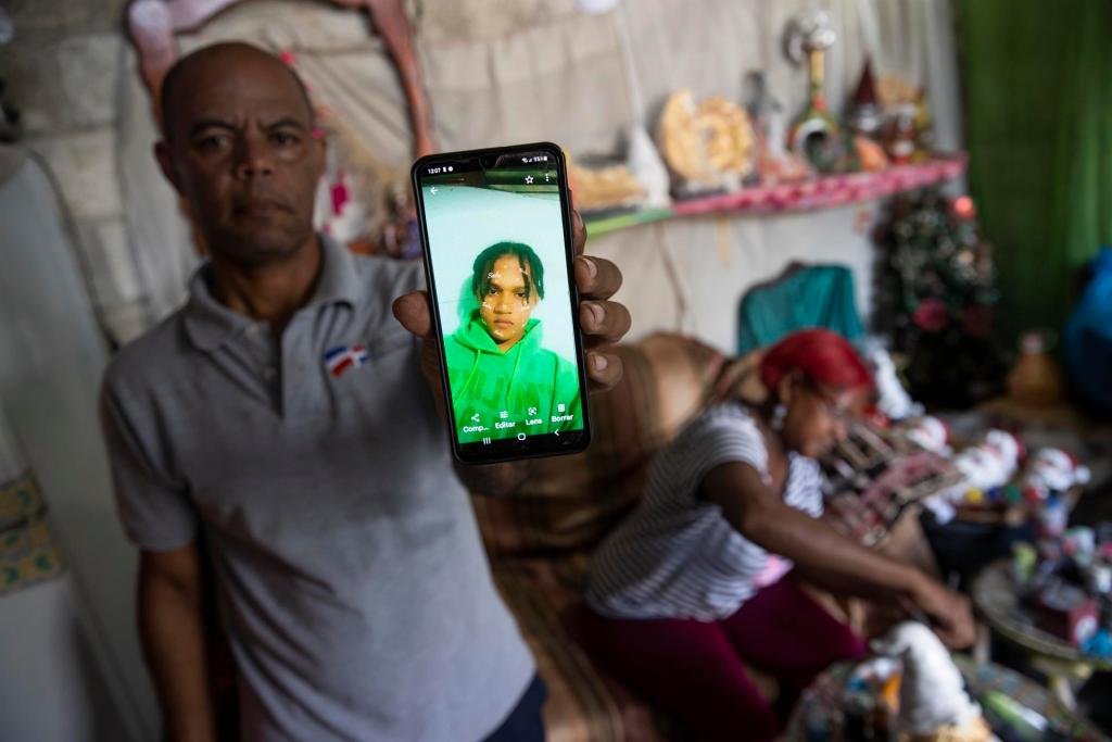 Julián Agramonte, acompañado de su esposa Raiza, muestra una fotografía de su hijo Marino (20 años), quien se encuentra en paradero desconocido, el 24 de octubre de 2022 en Santo Domingo Este (República Dominicana). EFE/Orlando Barría
