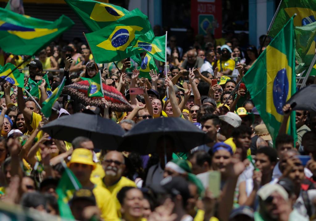 Centenas de personas se concentran en un pasadizo para acompañar el presidente brasileño Jair Bolsonaro en un acto de campaña presidencial, hoy en la ciudad de Sao Joao de Meriti, en Río de Janeiro (Brasil). EFE/Antonio Lacerda
