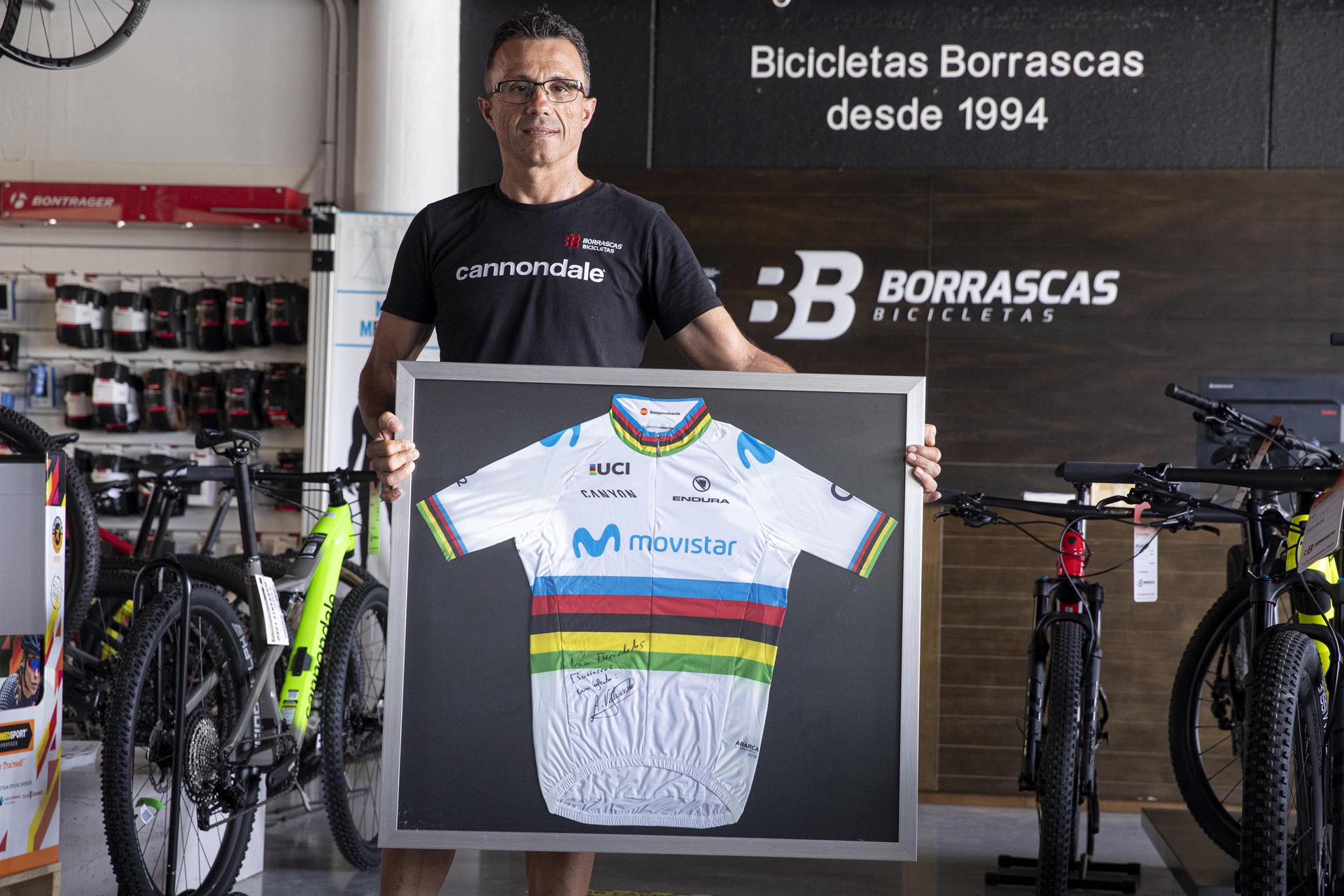 El propietario de la empresa de bicicletas Borrascas de Murcia Juan José Calatayud posa con el maillot de campeón del mundo de ciclismo que le regaló Alejandro Valverde, durante un momento de la entrevista que a concedido a Efe. EFE/Marcial Guillén
