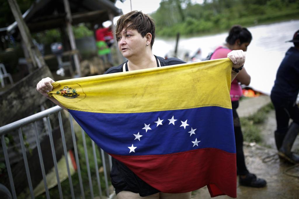 Karina Silva, una médica cirujana venezolana de 41 años, muestra la bandera de Venezuela a su llegada el 13 de octubre de 2022, al pueblo de Bajo Chiquito (Panamá), tras cruzar la selva del Darién migrando hacia los Estados Unidos. EFE/Bienvenido Velasco
