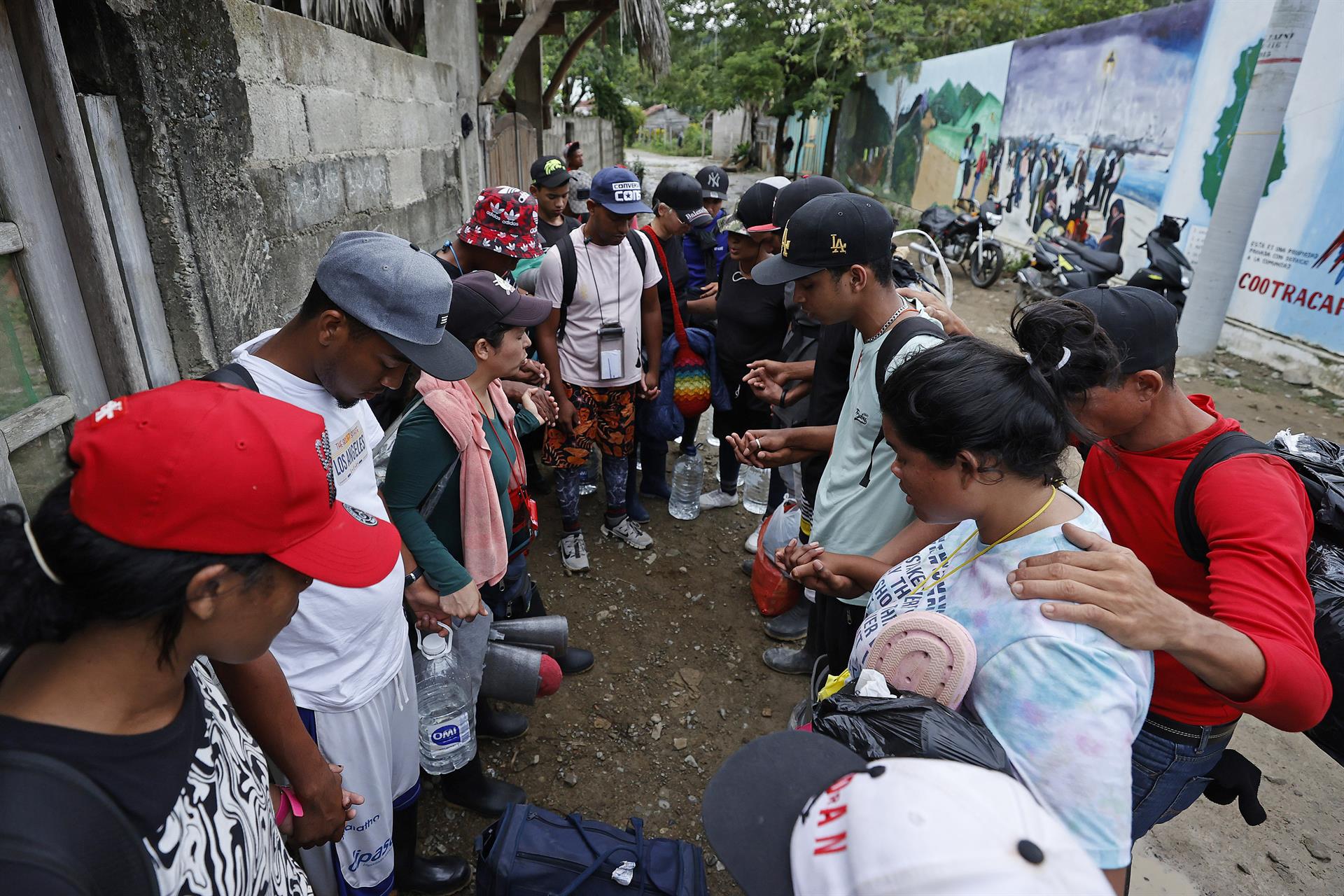 Migrantes venezolanos rezan antes de iniciar un recorrido con la intención de llegar a Panamá, el 8 de octubre de 2022, a través del Tapón del Darién (Colombia). EFE/Mauricio Dueñas Castañeda
