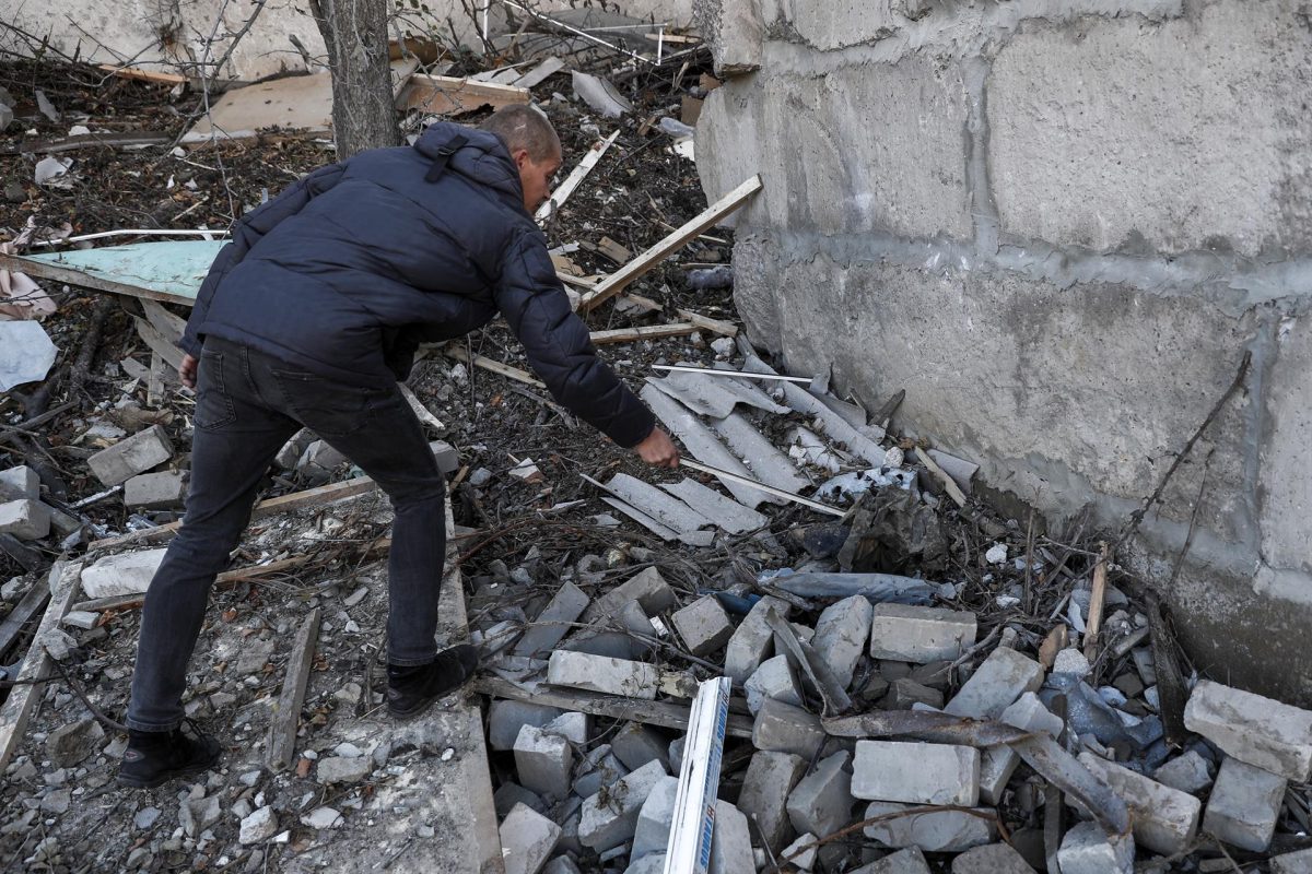 Un ucraniano inspecciona los restos de un soldado ucraniano entre los escombros de un edificio destruido en la ciudad de Kupiansk.