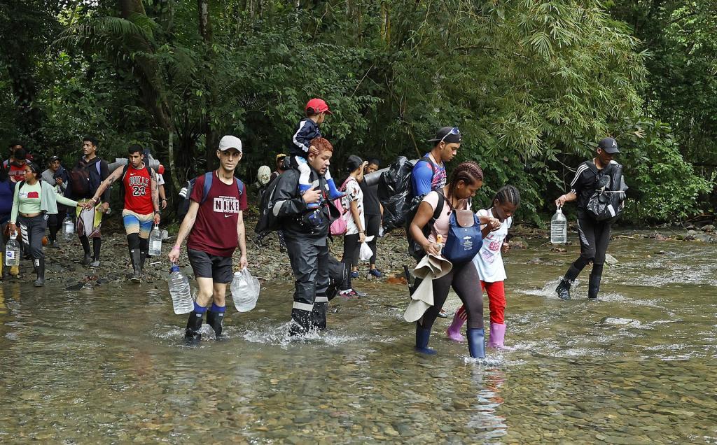 Migrantes atraviesan un río con la intención de llegar a Panamá, el 8 de octubre de 2022, a través del Tapón del Darién (Colombia). EFE/Mauricio Dueñas Castañeda
