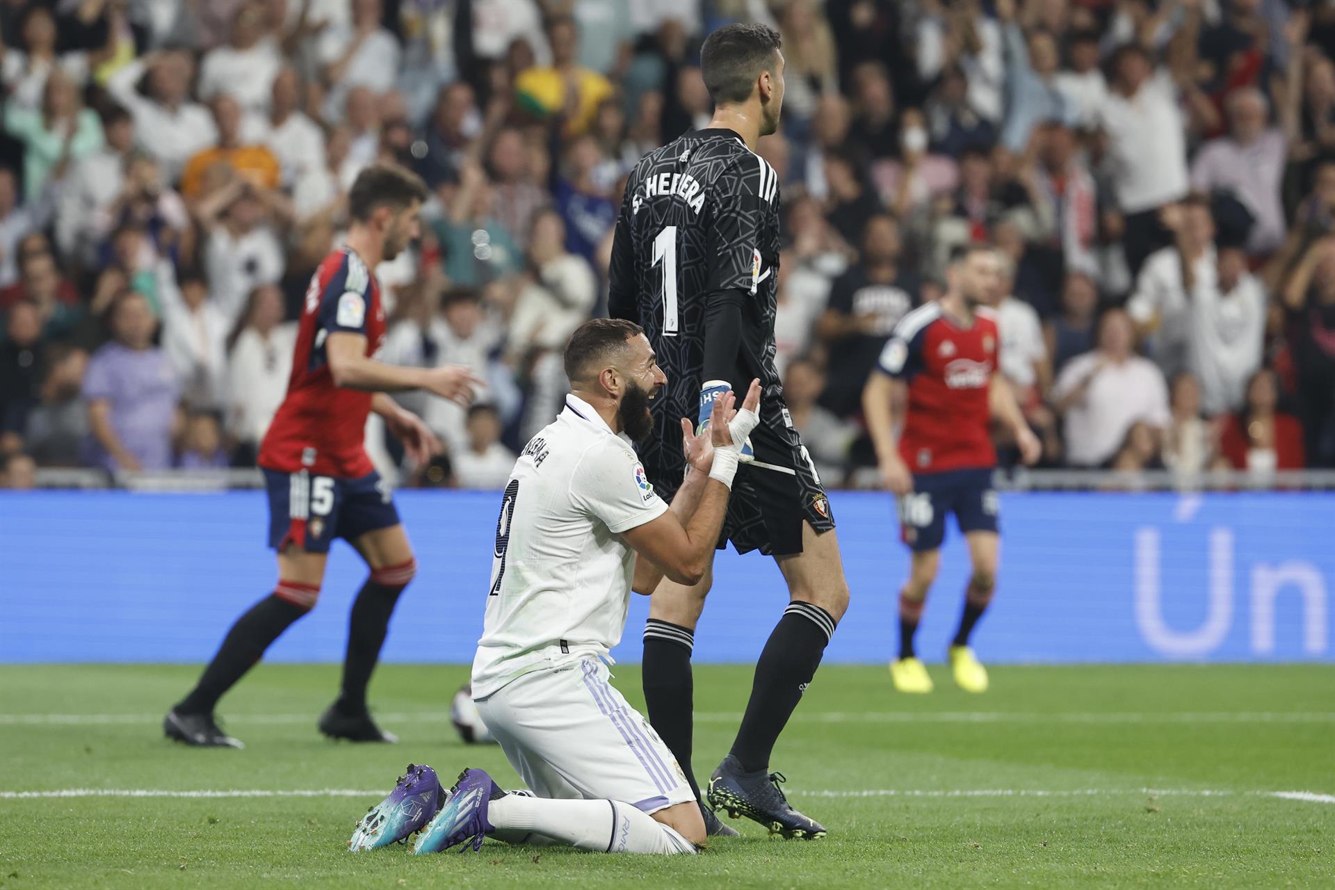 El delantero francés del Real Madrid, Karim Benzema, protesta la jugada que ha significado el penalti a favor del equipo blanco y la expulsión del defensor de Osasuna durante el encuentro correspondiente a la séptima jornada de primera división que disputaron en el estadio Santiago Bernabéu, en Madrid. EFE / Chema Moya.