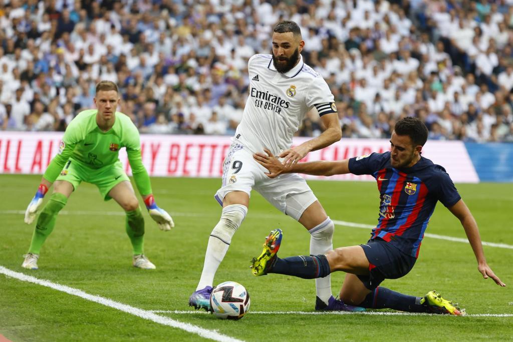 El defensa del FC Barcelona Eric García (d) pugna por el balón con el delantero del Real Madrid Karim Benzema.