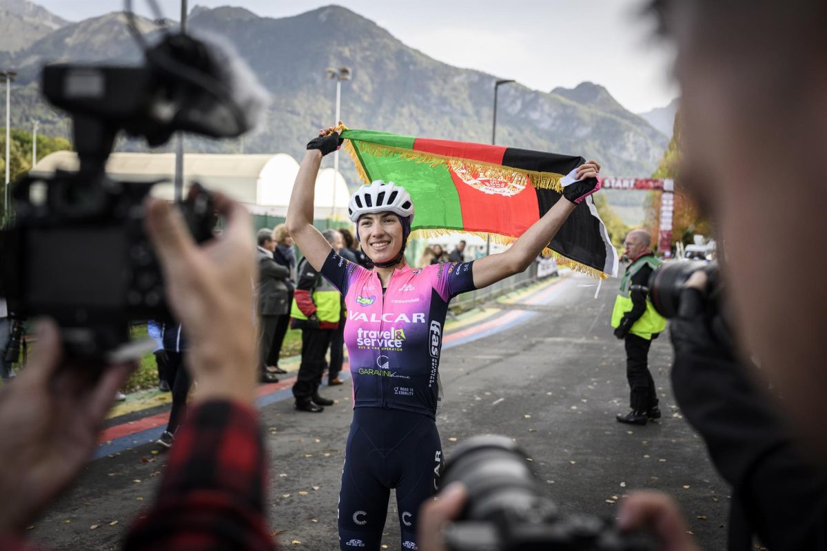 La ciclista afgana Fariba Hashimi posa para los medios con la bandera de su país, después de ganar el Campeonato de Ciclismo en ruta de Afganistán en Aigle, Suiza, una prueba que debido a la llegada al poder de los talibanes no puede celebrarse en Afganistán,.